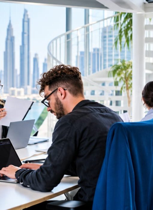 Dubai Finance team working with the Dubai skyline in the background